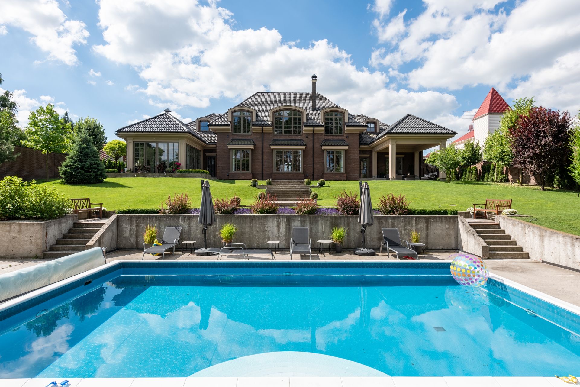 A large backyard swimming pool behind a brick home
